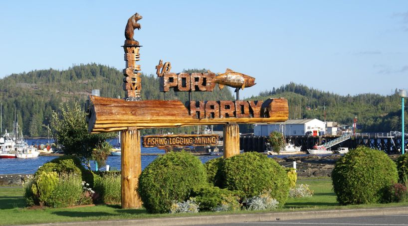 Wood Port Hardy welcome sign with carved bear and words "Welcome to Port Hardy".