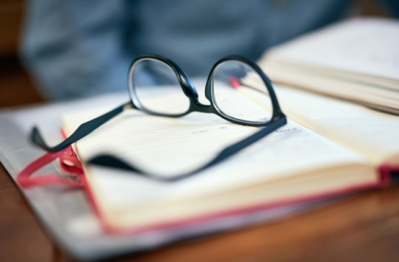 Pair of reading glasses laying on a book