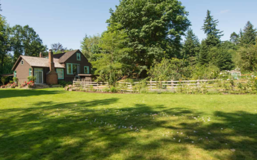 Above Tide, now the Haig-Brown Heritage House, taken on a sunny day with a grassy field in the foreground.