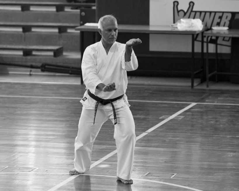 a man wearing martial arts clothes in a gymnasium