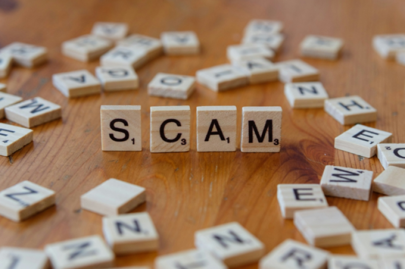 scrabble pieces spelling the word scam